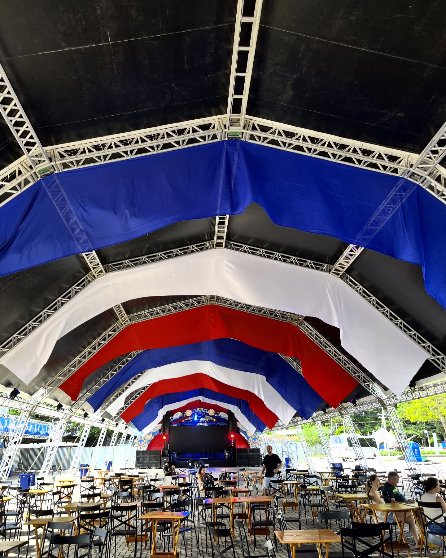 Cobertura cenográfica em tecido azul, branco e vermelho sobre arena de evento